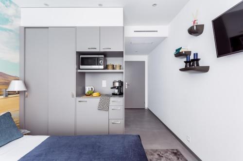 a kitchen with a white refrigerator and white cabinets at VISIONAPARTMENTS Rue des Communaux - contactless check-in in Vevey