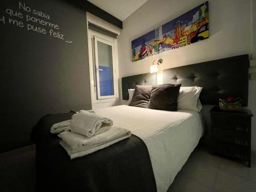 1 habitación con 1 cama con toallas en Hostal Lleida, en Barcelona