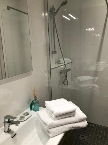 La salle de bains est pourvue d'un lavabo, d'une douche et de serviettes. dans l'établissement LE GRUFFAZ - Hyper centre, Balcon sur canal, à Annecy