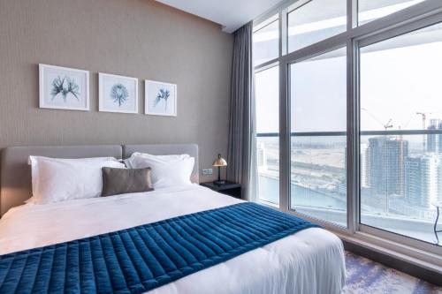a bedroom with a large bed and a large window at The Smart Concierge - Damac Prive in Dubai