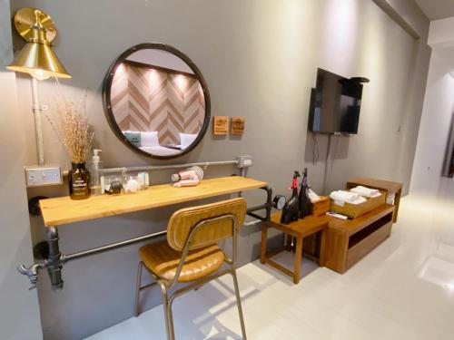 a bathroom with a vanity and a mirror and a chair at Little B&B in Taitung City