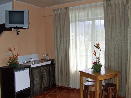 una cucina con lavandino e una TV a parete di Hotel Arenal By Regina a Fortuna