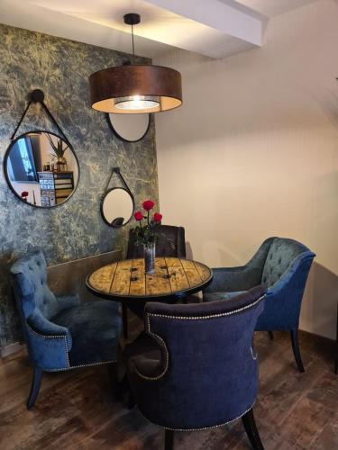 a dining room with a table and chairs and a mirror at Ma nuit ô spA in Reims