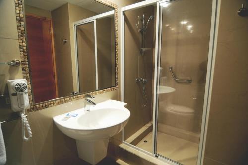 uma casa de banho com um lavatório, um chuveiro e um WC. em Hotel Ontiveros em San Fernando