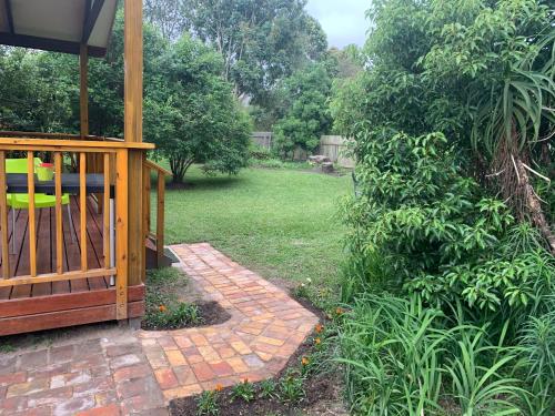 a garden with a brick walkway next to a bush at Mad About Saffron in Stormsrivier