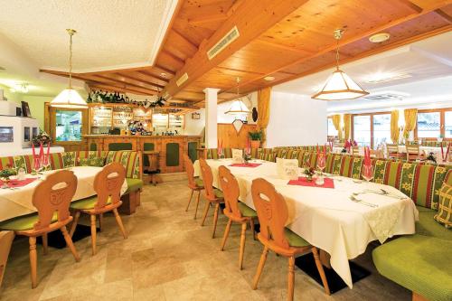 a restaurant with tables and chairs in a room at Hotel Gratz Großarl in Grossarl