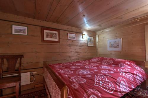 - une chambre avec un lit rouge dans une cabine dans l'établissement B&B La Pivoine, à Rossinière