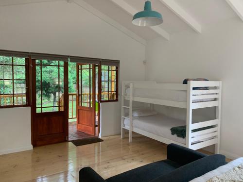 a bedroom with a bunk bed and a living room at Mad About Saffron in Stormsrivier