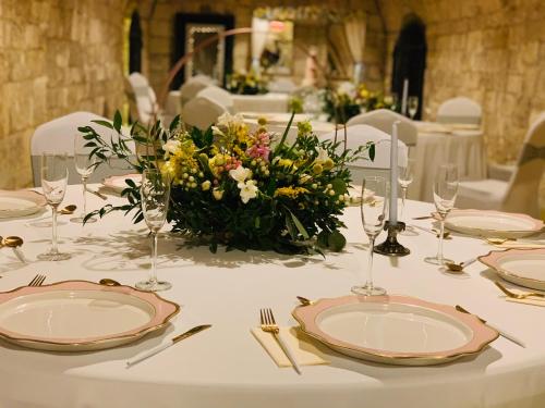 a table with plates and a flower arrangement on it at Boutique Hotel & Event Center in Budapest
