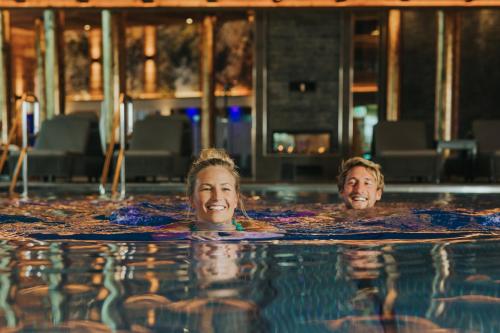 a man and woman swimming in a swimming pool at Ortner's Resort in Bad Füssing
