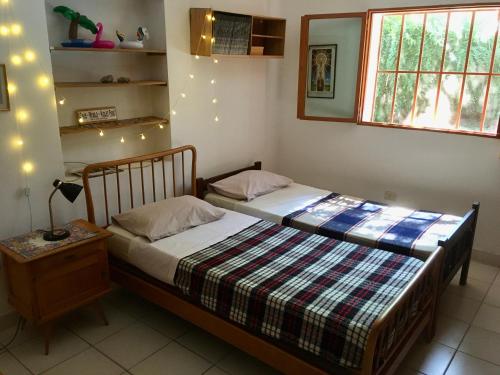 dwa łóżka w sypialni z oświetleniem na ścianie w obiekcie Lo de Jenny w mieście San Marcos Sierra