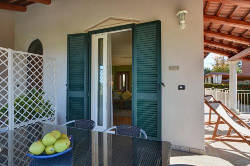 a dining room with green doors and a table with a bowl of apples at La Rosa Gialla Bio Apartments & rooms in Barolo