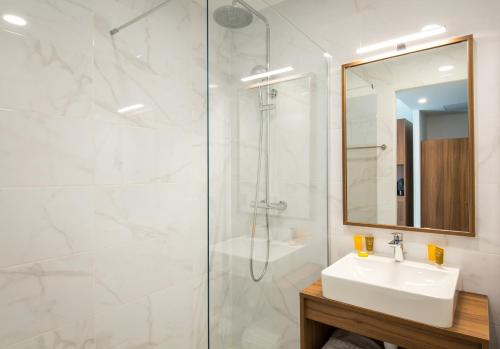 a bathroom with a sink and a shower at SOWELL HOTELS La Plage in Saint-Raphaël