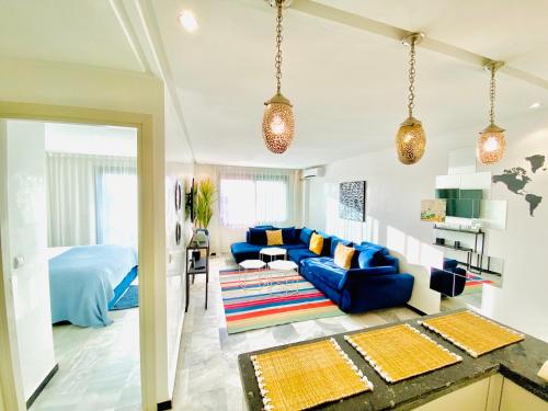 a living room with a blue couch and a bed at AiM HOUSE in Marrakech