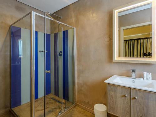 a bathroom with a shower and a sink and a mirror at St Michaels Sands Hotel & Time Share Resort in Shelly Beach
