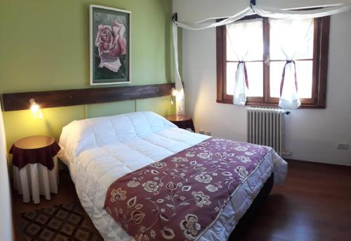 1 dormitorio con 1 cama grande y 2 ventanas en pampa en San Carlos de Bariloche