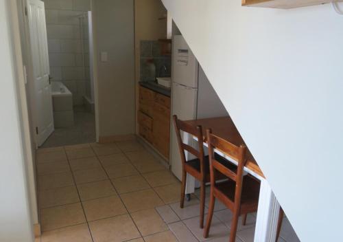 a kitchen with a table and chairs and a bathroom at Adagio Luxury Self Catering in Stilbaai