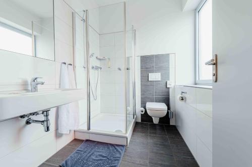 a bathroom with a shower and a sink and a toilet at Gästehaus DEULA in Warendorf
