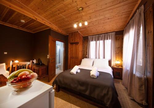 ein Schlafzimmer mit einem Bett und einer Obstschale auf einem Tisch in der Unterkunft Stone Suites by White Hills in Arachova