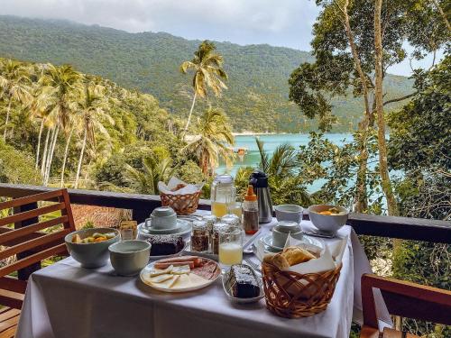 a table with food and a view of the ocean at Atlantica Jungle Lodge in Abraão