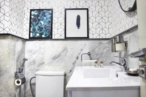 a bathroom with a sink and a toilet and two framed pictures at AiM HOUSE in Marrakech