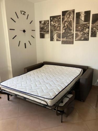 un letto in una stanza con un orologio a muro di Raggio di Sole a Sestri Levante