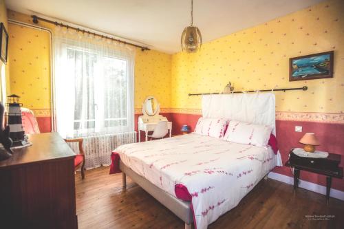 - une chambre avec un lit et un mur jaune dans l'établissement Hon-ty, à Groix