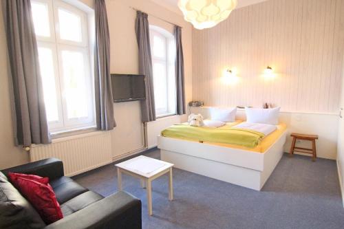 une chambre d'hôtel avec un lit et un canapé dans l'établissement Kapitaenshaus-Lassen-Zimmer-Amistad, à Westerland