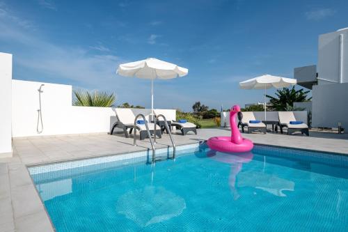 a swimming pool with a pink flamingo in the water at ASTERIA PEARL VILLA 2 with Rooftop Jacuzzi in Tigaki