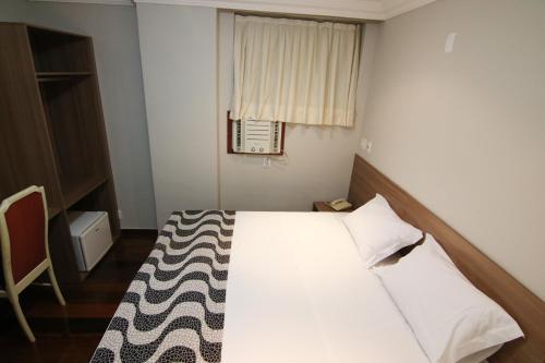 a small bedroom with a bed and a window at Samba Belo Horizonte Centro in Belo Horizonte