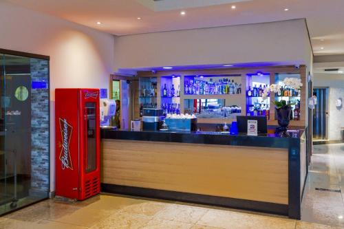a red coke machine sitting next to a bar at Transamerica Prestige Recife - Boa Viagem in Recife