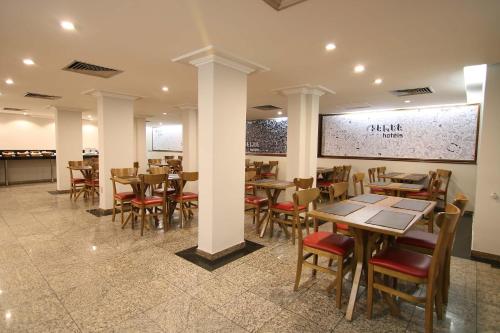 a restaurant with tables and chairs in a room at Samba Belo Horizonte Centro in Belo Horizonte