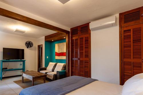 a bedroom with a bed and a living room at Atlantica Jungle Lodge in Abraão