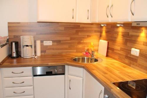 a kitchen with a sink and a wooden counter top at Nordsee-Residenz-City-App-18 in Westerland