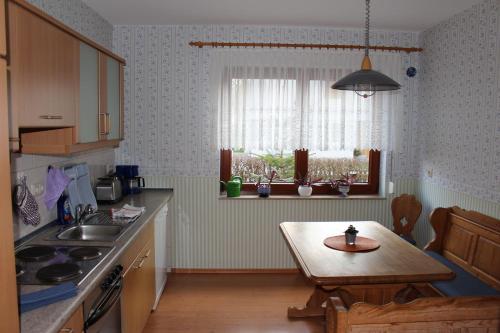 eine Küche mit einem Tisch, einem Waschbecken und einem Fenster in der Unterkunft Ferienwohnung Illgen in Dresden
