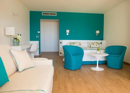 a living room with a couch and a table at El Faro Hotel & Spa in Porto Conte