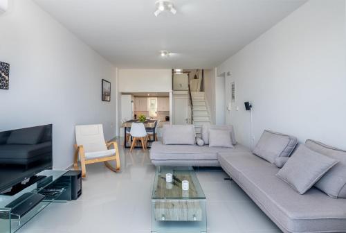 a living room with a couch and a table at ASTERIA PEARL VILLA 2 with Rooftop Jacuzzi in Tigaki