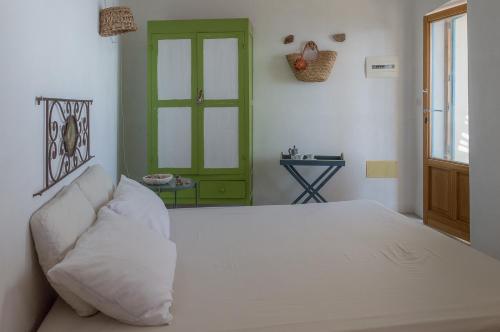 a bedroom with a white bed and a green door at Casa Artemisia in Filicudi