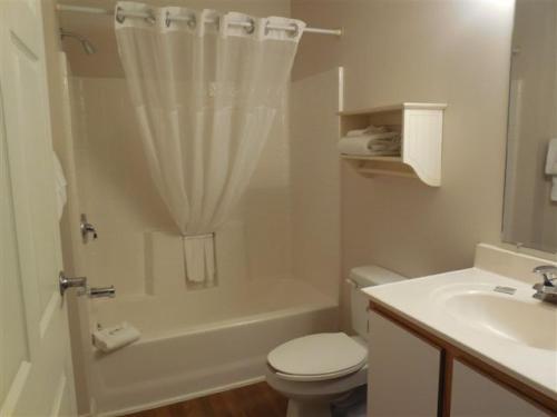 a white bathroom with a toilet and a sink at Affordable Suites Shelby in Shelby