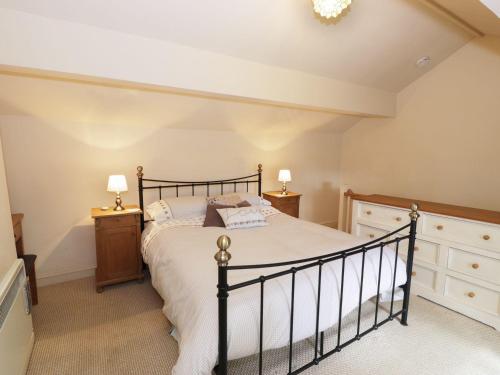 a bedroom with a bed and two night stands at Menai Cottage in Llanfairpwllgwyngyll
