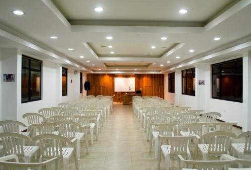 a room with rows of white chairs and a podium at Casa del Peregrino Santo Thomas in Baños