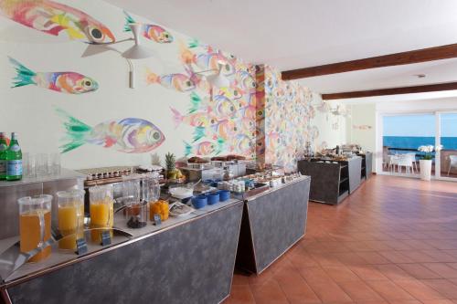 a restaurant with a buffet line with orange juice at Hotel Villa Domizia in Porto Santo Stefano