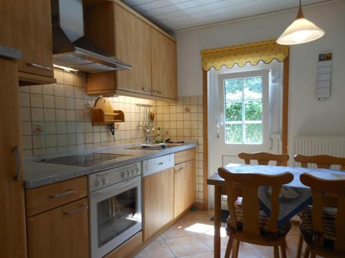 a kitchen with a stove and a table with chairs at Bungalow-Lerchennest in Wittdün