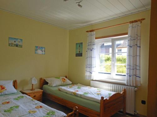 a bedroom with two beds and a window at Bungalow-Lerchennest in Wittdün