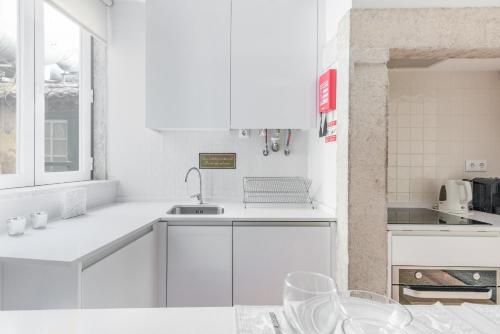 a white kitchen with white cabinets and a sink at Lisbon Center IV in Lisbon