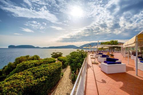 a view of the water from the balcony of a resort at El Faro Hotel & Spa in Porto Conte