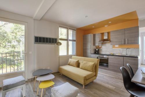 un salon avec un canapé et une cuisine dans l'établissement Le Cottage Nature Loin de l'oeil Clim Gaillac entre Albi-Toulouse & Les Cottages du Tarn, à Brens