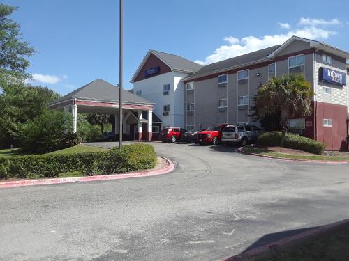 a hotel with cars parked in a parking lot at InTown Suites Extended Stay Houston TX - IAH Airport in Houston