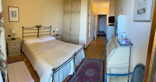 a bedroom with a bed and a dresser and a refrigerator at LA SISMONDA in Rodello