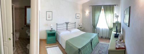 a small bedroom with a bed and a bathroom at LA SISMONDA in Rodello